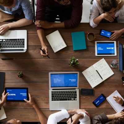 people around a table with laptops